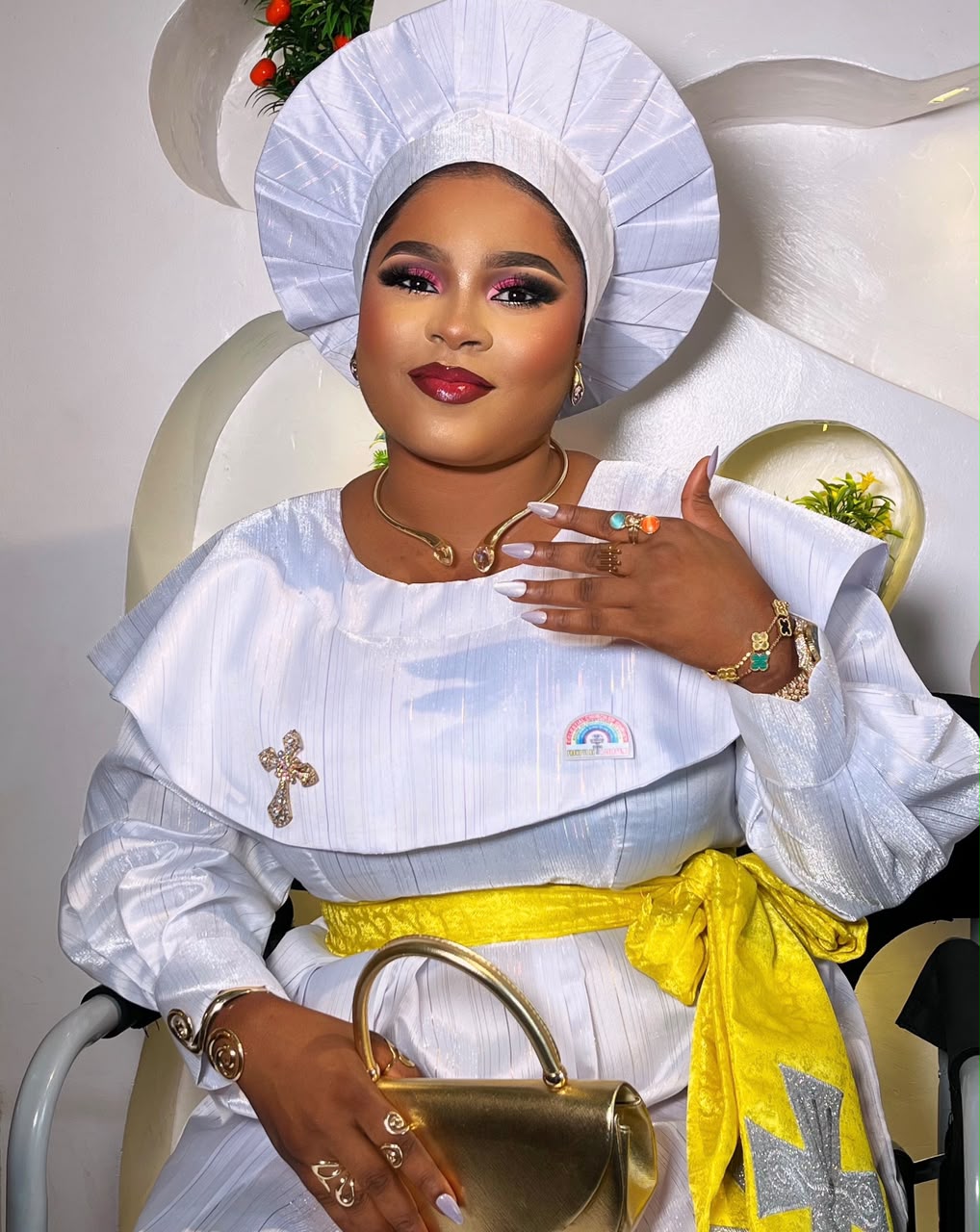 White outfit with yellow sash, seated